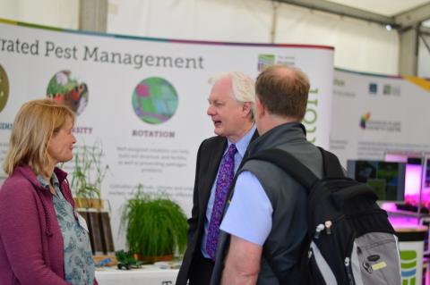 IPM@Hutton members talking about IPM research at the James Hutton Institute with a member fo the public and the 2019 Royal Highland Show